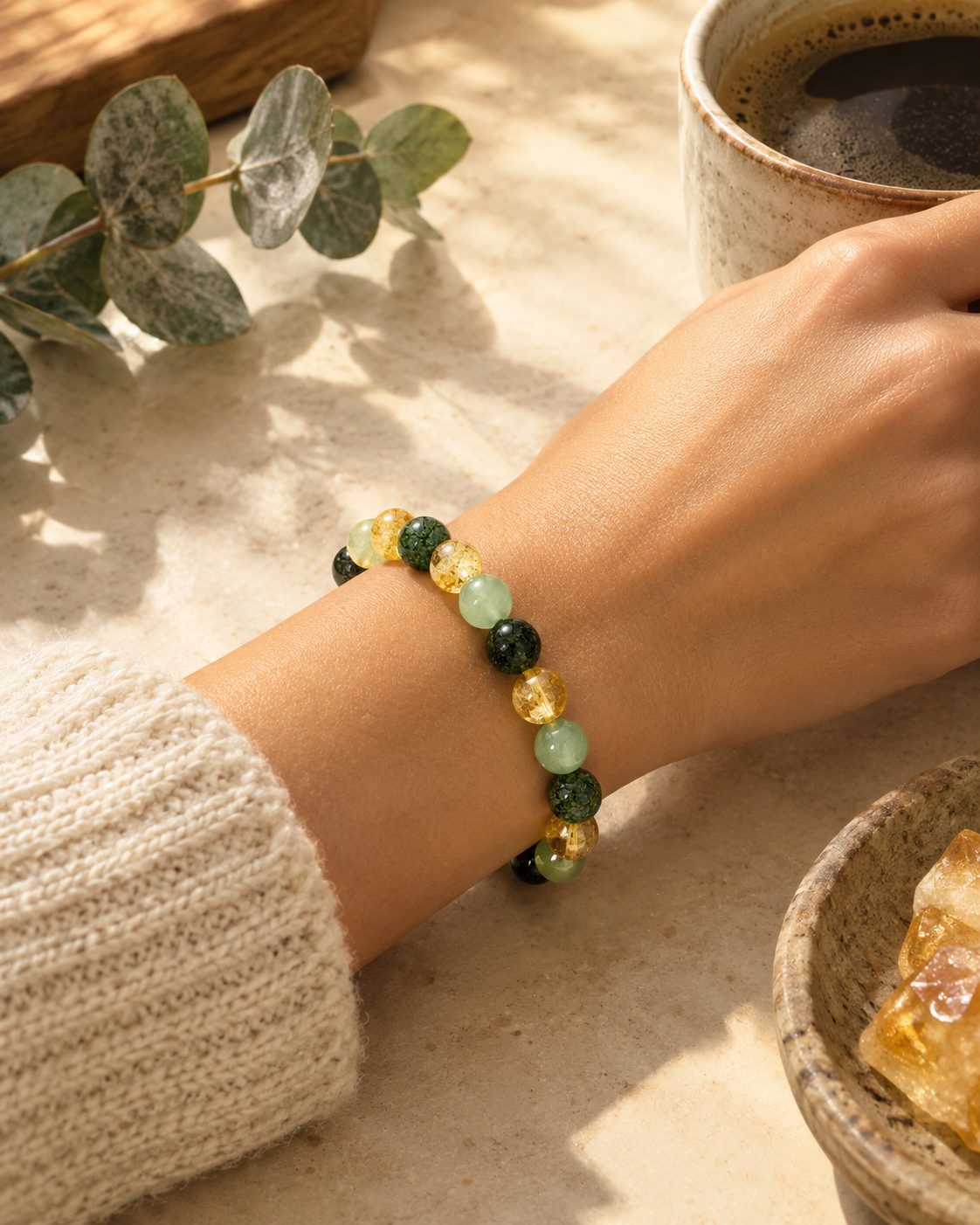 Wrist wearing the bracelet, morning coffee in soft light